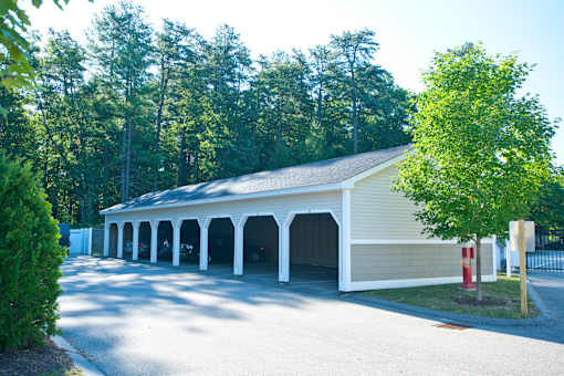 A yellow building with white pillars and a red fire hydrant in front.