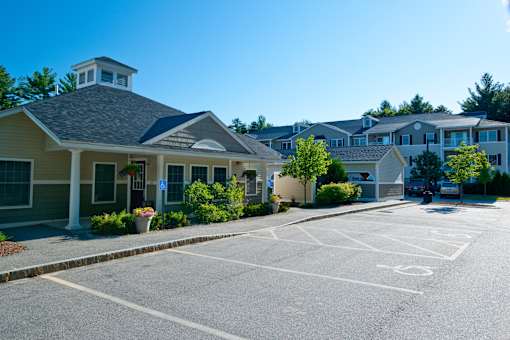 A parking lot in front of a building with a blue sky in the background.