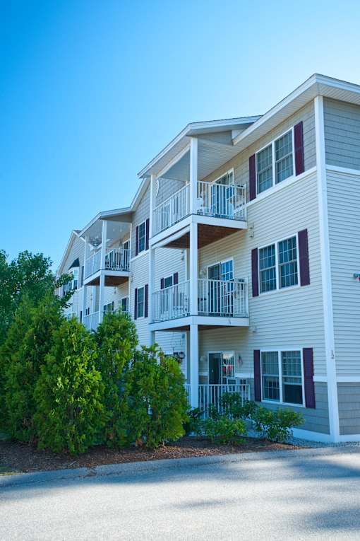 A two-story apartment building with balconies and multiple windows.