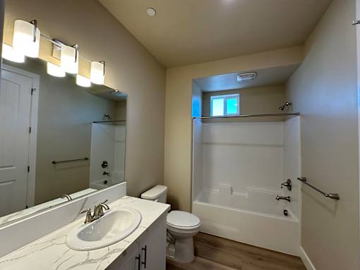A white bathroom with a sink, toilet, and bathtub.