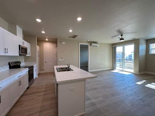A kitchen with white cabinets and a large island.