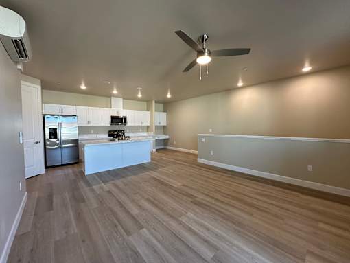 A spacious kitchen with a refrigerator, microwave, and oven.