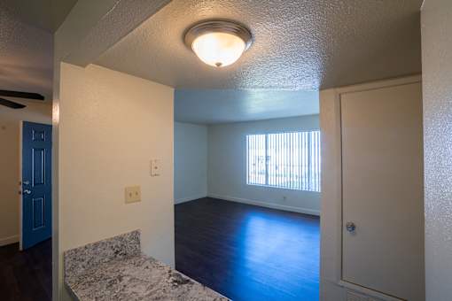 A room with a ceiling fan and a window with blinds.