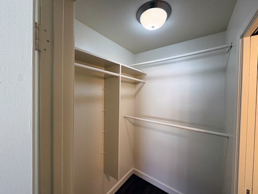A white closet with a light on the ceiling.