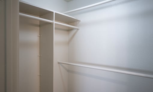 A white closet with shelves and a door.