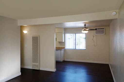 A room with a ceiling fan and a window with blinds.