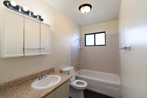 A bathroom with a sink, toilet, and bathtub.