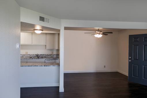 A room with a ceiling fan and a wall-mounted light fixture.