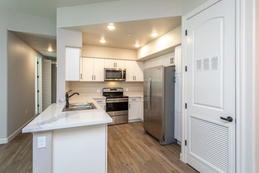 a kitchen with white cabinets and stainless steel appliances