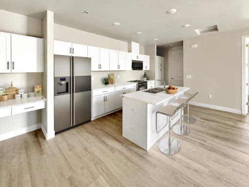 a large white kitchen with stainless steel appliances and a white island