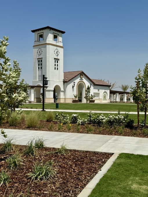 a building with a clock tower in the middle of a sidewalk