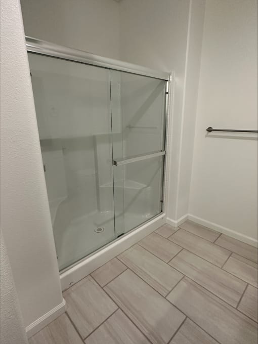 a shower in a bathroom with a sliding glass door