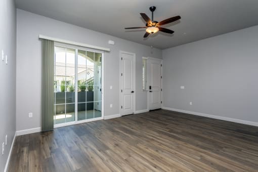 an empty living room with a ceiling fan