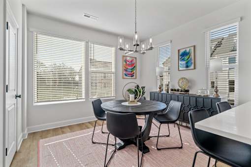 A dining room with a round table and chairs.