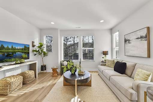 A living room with a large couch, a coffee table, and a painting on the wall.
