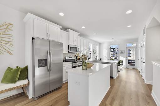 A modern kitchen with a stainless steel refrigerator and white cabinets.