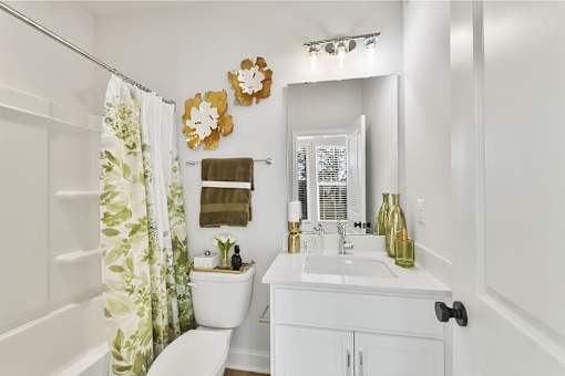 A white bathroom with a toilet, sink, and shower.