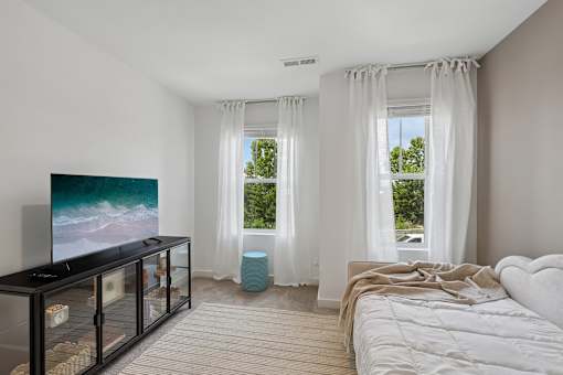 A modern bedroom with a large bed and a television.