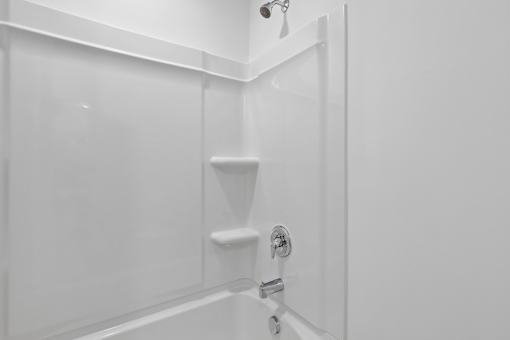 A white bathroom with a shower and a glass door.