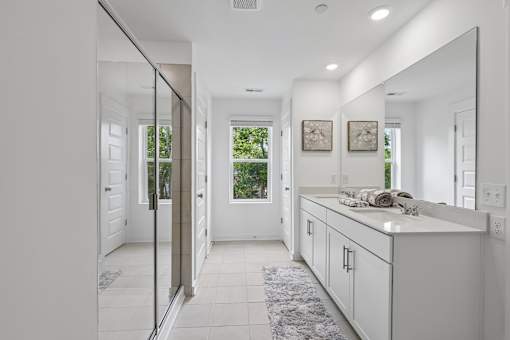 A white kitchen with a large mirror on the wall.