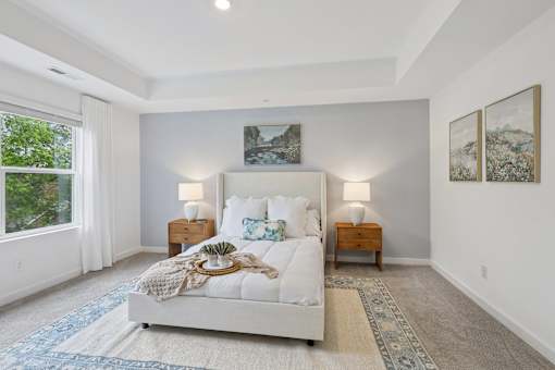 A bedroom with a large bed and two lamps.