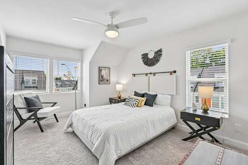 A bedroom with a bed, chair, and window.