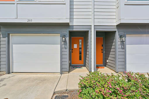 The image shows the front of a building with the number 203 on it.