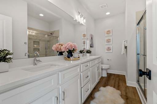 A bathroom with a white vanity and a mirror above it.