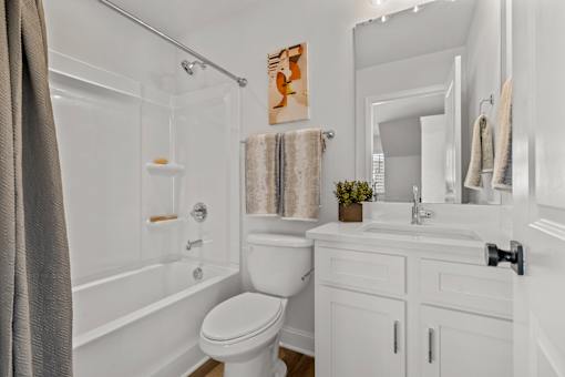 A white bathroom with a toilet, sink, and bathtub.