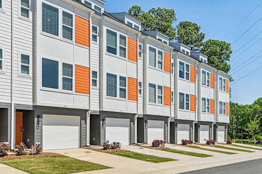 A row of modern townhouses with orange and grey accents.