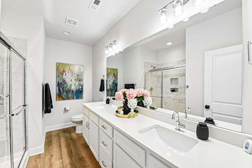 A bathroom with a white sink and a large mirror.