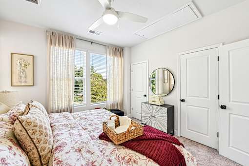 A bedroom with a large bed and a window with curtains.