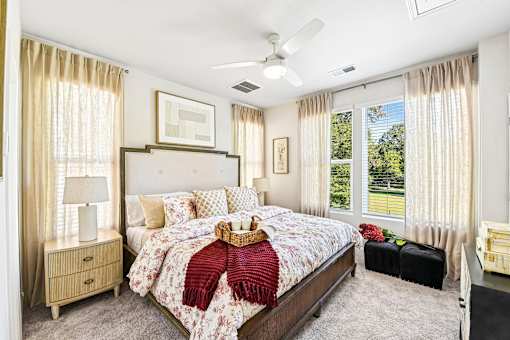 A bedroom with a large bed and a ceiling fan.
