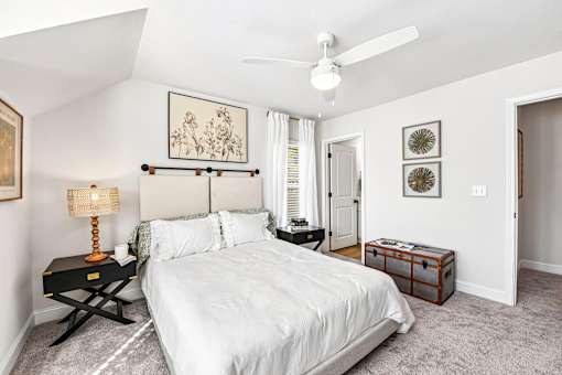 A bedroom with a large bed and a ceiling fan.