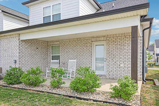 A house with a white porch and a grey roof.
