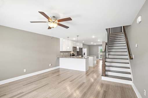 A spacious living room with a staircase leading to the upper floor.