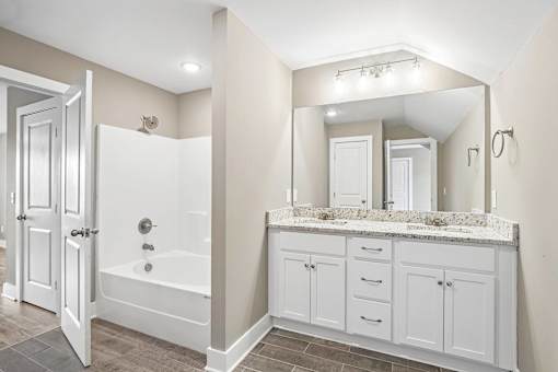 A bathroom with a white tub and vanity.