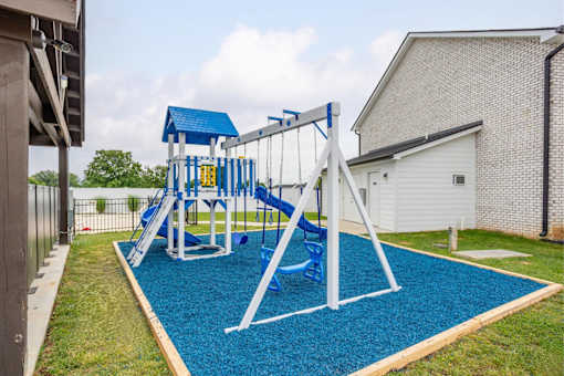 A playground with a blue slide and a white frame.