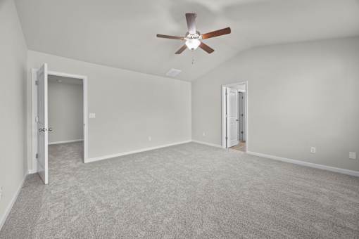 A room with a ceiling fan and carpeted floor.