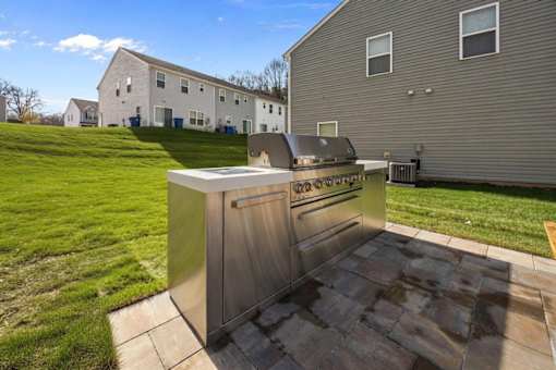 A modern outdoor kitchen with a grill and sink.