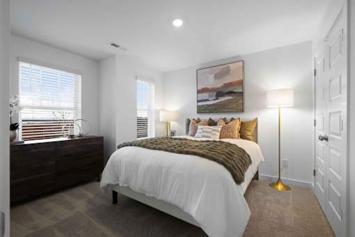A bedroom with a large bed and a painting on the wall.