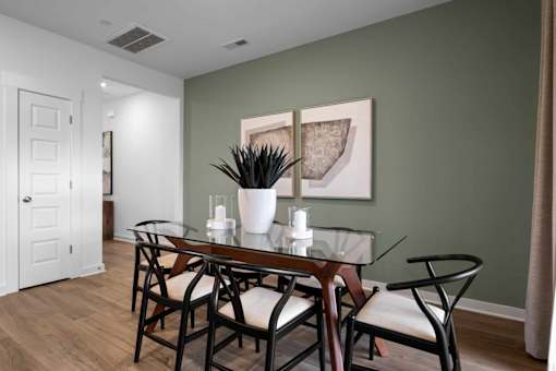 A dining room with a glass table and chairs.