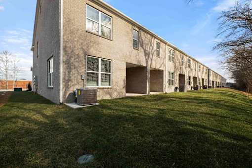 A long building with a green lawn in front.