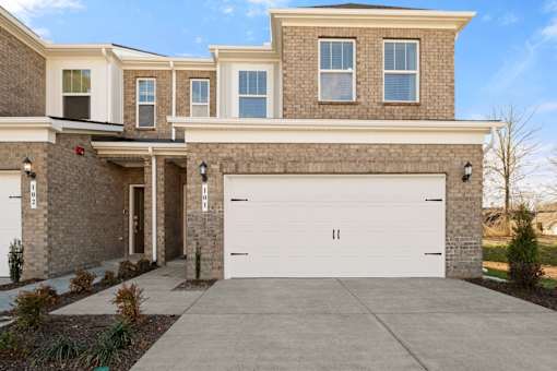 A two-story house with a garage door.