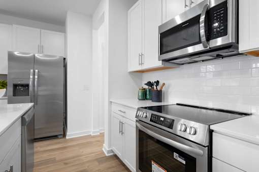 A modern kitchen with stainless steel appliances and white cabinets.