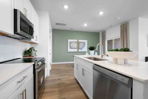 A modern kitchen with white cabinets and stainless steel appliances.