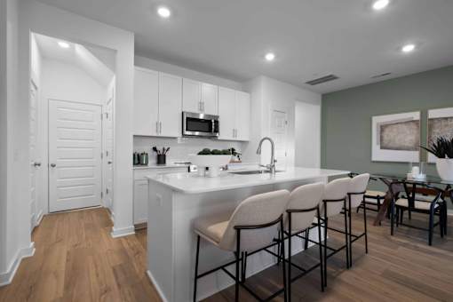 A modern kitchen with white cabinets and a large island.