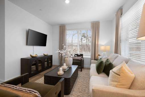 A modern living room with a flat screen TV mounted on the wall.