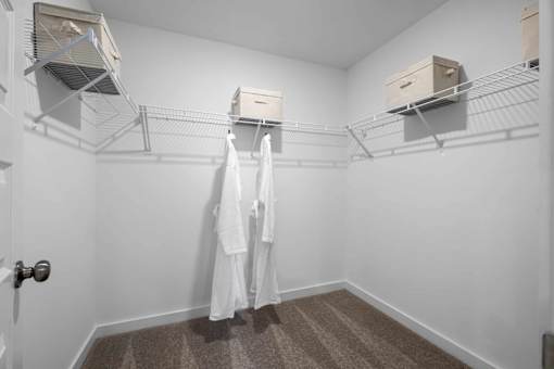 A white bathroom with a towel hanging on the rack.