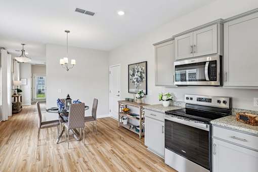 A kitchen with a dining table and chairs.